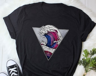 May include: Black t-shirt with a graphic of a blue, pink, and white wave inside a triangle.