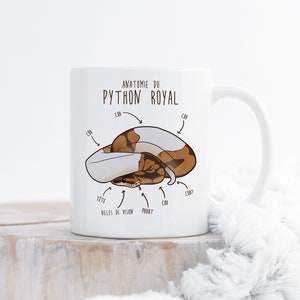 May include: White ceramic mug with a brown and white python illustration and the text "Anatomie du Python Royal" in French. The illustration shows the snake's head, eyes, body, and tail.