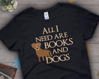 May include: Black t-shirt with the text "All I need are books and dogs" in tan lettering. A brown dog illustration is to the left of the text.