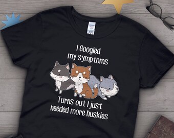 May include: Black t-shirt with a white graphic of three cartoon huskies. The text reads "I Googled my symptoms Turns out I just needed more huskies."
