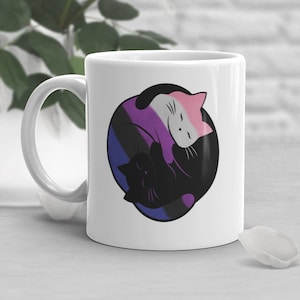 Puede incluir: Taza de cerámica blanca con un diseño de gato blanco y negro. Los gatos están acurrucados en un símbolo yin yang con los colores de la bandera del orgullo bisexual.