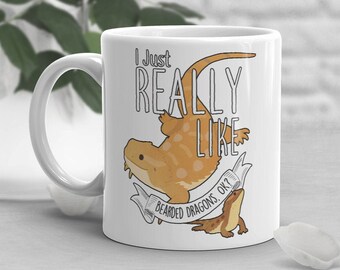 Puede incluir: Taza de cerámica blanca con un dragón barbudo de dibujos animados y el texto "Me gustan mucho los dragones barbudos, ¿de acuerdo?" impreso en ella.