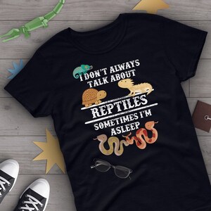 May include: Black t-shirt with a white graphic design featuring a chameleon, turtle, lizard, and snake. The text reads "I don't always talk about reptiles, sometimes I'm asleep."