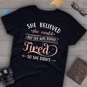 May include: Black t-shirt with a pink graphic that says "She believed she could but she was really tired so she didn't."