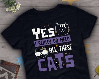 May include: Black t-shirt with a purple graphic that says "Yes I really do need all these cats". The graphic features a black cat with sunglasses and a black cat with a white face.
