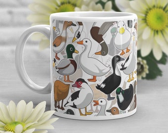 May include: White ceramic mug featuring a colorful pattern of various duck illustrations. The ducks are depicted in different poses and colors, including white, brown, black, and green. The mug has a white handle and a glossy finish.