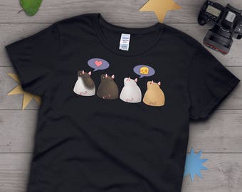 May include: Black t-shirt featuring a cartoon design of four hamster-like creatures. Two speech bubbles show a heart and a cheese wedge. The hamsters are in shades of brown, white, and tan. The shirt has a crew neck.