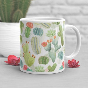 May include: White ceramic mug with a colorful cactus pattern. The mug has a handle and is filled with a variety of cacti in different colors and shapes.