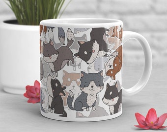 May include: White ceramic mug with a repeating pattern of cartoon dogs in various colors, including black, gray, brown, and blue. The dogs are all facing forward and have different expressions.