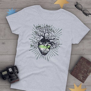 May include: A grey t-shirt featuring a green, white and black heart with a tree growing from it. The heart is surrounded by a sunburst design.