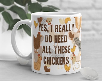 Pode incluir: Caneca de cerâmica branca com um padrão de galinhas marrons, amarelas e brancas. A caneca tem o texto "YES, I REALLY DO NEED ALL THESE CHICKENS" impresso nela.
