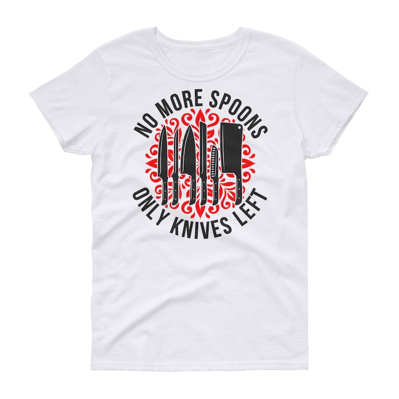 Puede incluir: Camiseta blanca con un dise&ntilde;o circular rojo que presenta un conjunto de cuchillos y el texto "No More Spoons Only Knives Left".