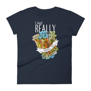 May include: A navy blue women's t-shirt with the text "I Just Really Like Canning, Ok?" in white. The shirt features a colorful illustration of jars of preserved food.