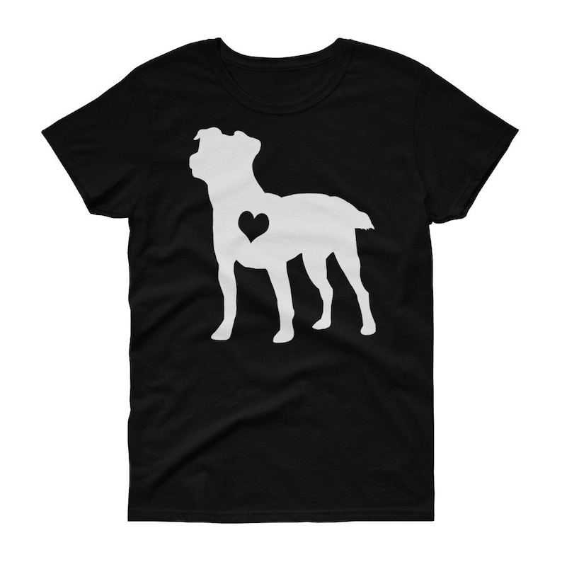 May include: A black t-shirt featuring a white silhouette of a dog with a heart on its chest.