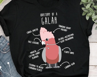 May include: Black t-shirt featuring a cartoon illustration of a Galah, with labeled anatomical features such as "Chaos-ometer" and "Flappy Arms." The text "Anatomy of a Galah" is at the top.