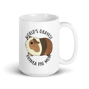 May include: White ceramic mug with a brown and white guinea pig illustration and the text "World's Okayest Guinea Pig Mom".