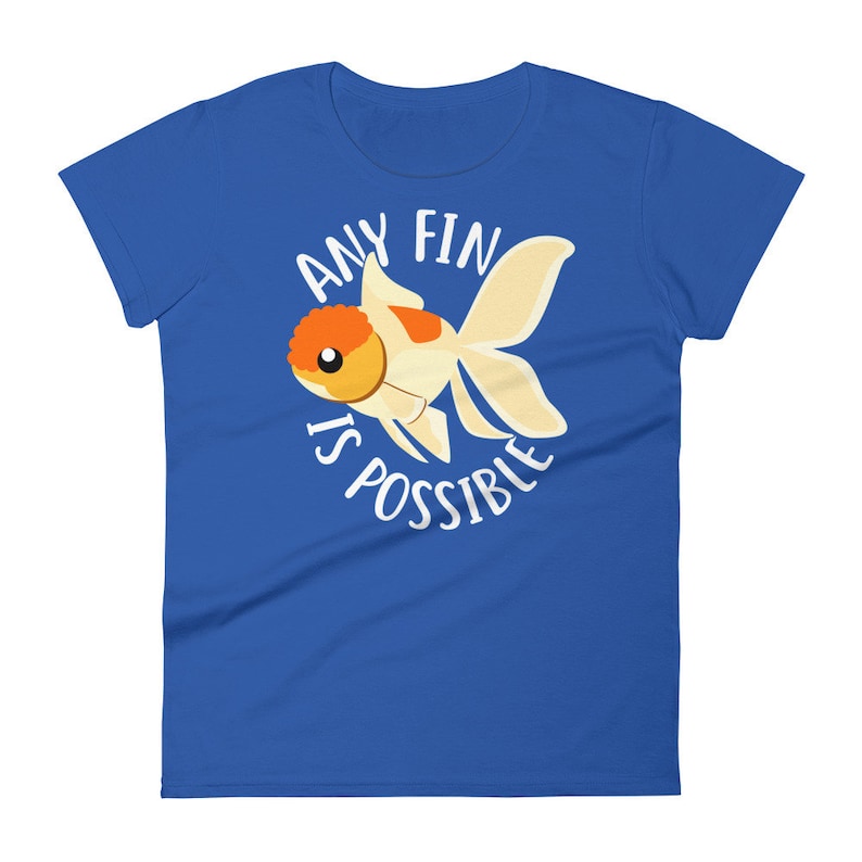 May include: A royal blue women's t-shirt with a white circle graphic featuring a cartoon goldfish and the text "Any Fin Is Possible".