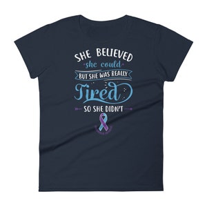 May include: Navy blue women's t-shirt with the text "She believed she could, but she was really tired, so she didn't."  The text is in a light blue color with a purple ribbon below it that says "Bipolar Awareness".