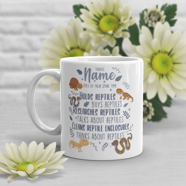 Puede incluir: Taza de cer&aacute;mica blanca con una ilustraci&oacute;n azul y marr&oacute;n de reptiles y el texto "THINGS Name DOES IN THEIR SPARE TIME"  *HOLDS REPTILES *BUYS REPTILES *RESEARCHES REPTILES *TALKS ABOUT REPTILES CLEANS REPTILE ENCLOSURES THINKS ABOUT REPTILES