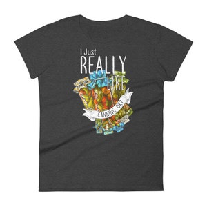 May include: A dark gray women's t-shirt with the text "I Just Really Like Canning, Ok?" in white. The text is surrounded by a colorful illustration of jars of canned goods.