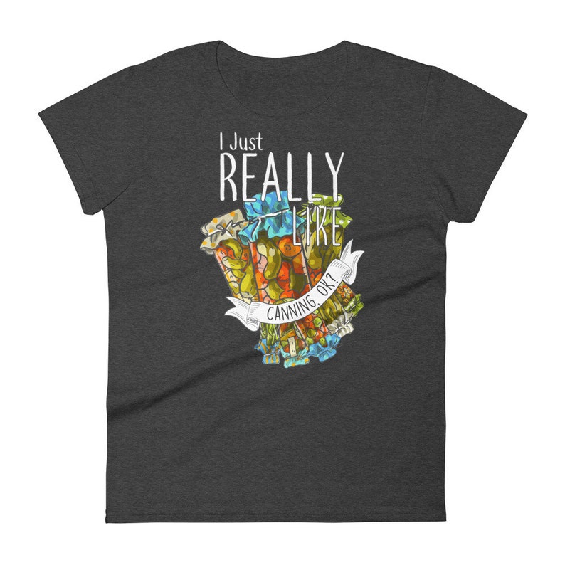 May include: A dark gray women's t-shirt with the text "I Just Really Like Canning, Ok?" in white. The text is surrounded by a colorful illustration of jars of canned goods.