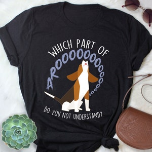 Puede incluir: Camiseta negra con un gráfico blanco de un perro aullando con el texto "¿Qué parte de AROOOOOO no entiendes?"
