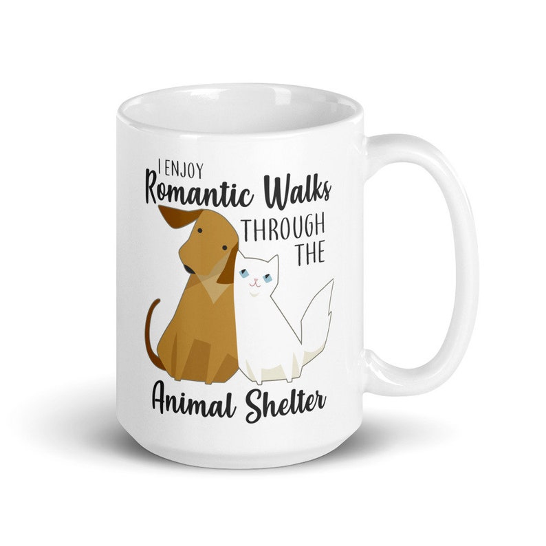 May include: White ceramic mug with a brown dog and white cat illustration. The text reads "I enjoy Romantic Walks through the Animal Shelter".