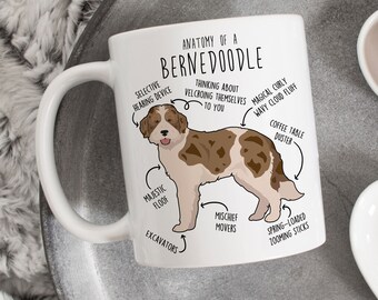 May include: White ceramic mug with a brown and white Bernedoodle dog illustration. The mug features a humorous anatomical chart with labels like "Selective Hearing Device", "Majestic Floof", and "Spring-Loaded Zooming Sticks".