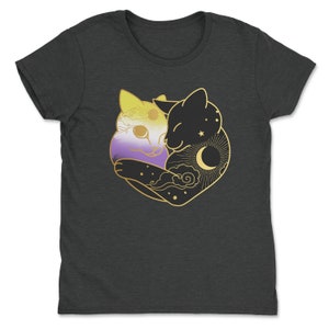 Op de afbeelding: Donkergrijs T-shirt met een gouden afbeelding van twee omhelzende katten. E&eacute;n kat is gekleurd in de kleuren van de non-binaire pride vlag, de andere is zwart met een zon-, maan- en sterrenontwerp. De katten omarmen elkaar.