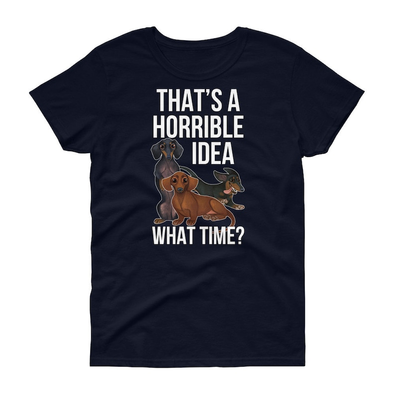 May include: Navy blue women's t-shirt with a white graphic of three dachshunds. The text "That's a horrible idea. What time?" is printed on the shirt.