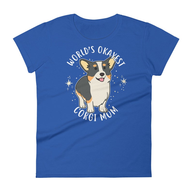 May include: A royal blue t-shirt with a white graphic of a cartoon corgi dog. The text "World's Okayest Corgi Mum" is printed around the dog.