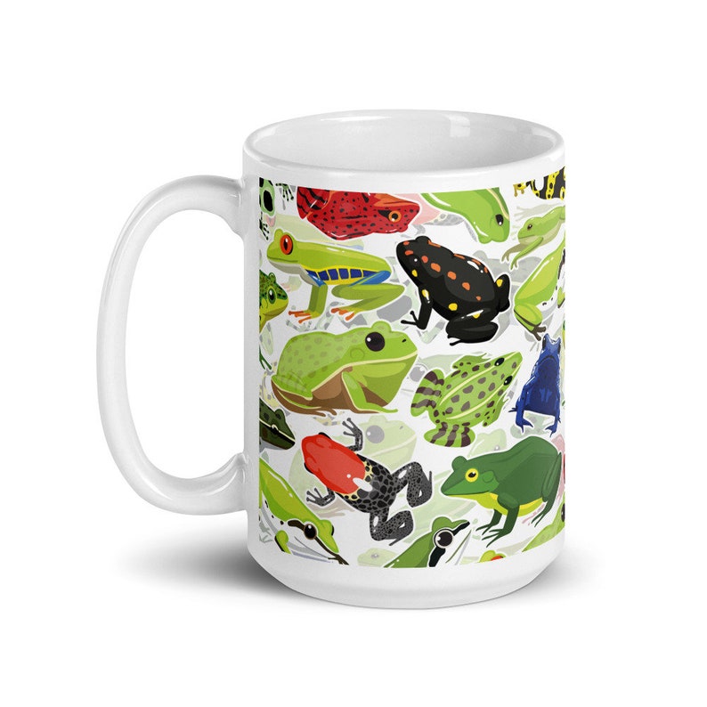 May include: White ceramic mug with a colorful pattern of frogs. The frogs are green, red, black, blue, and yellow. The mug is 15 ounces.