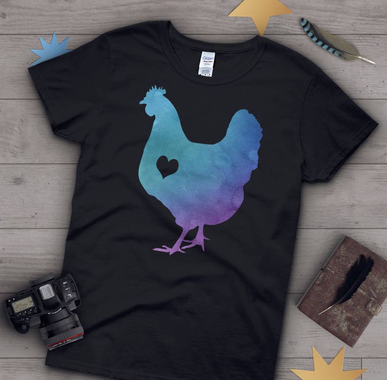 Pode incluir: Uma camiseta preta com uma silhueta de frango em estilo aquarela com um cora&ccedil;&atilde;o no peito. O frango &eacute; azul, roxo e verde.