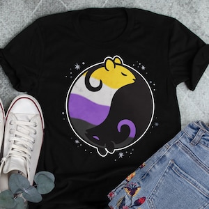 May include: Black t-shirt with a yin yang symbol featuring two mice. The yin yang symbol is in the colors of the non-binary pride flag: yellow, white, purple, and black.