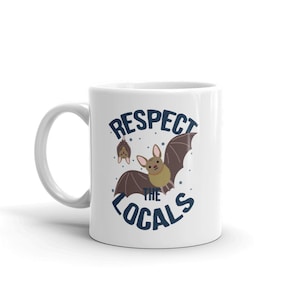 May include: White ceramic mug with a blue and white design featuring bats and the text "Respect the Locals".