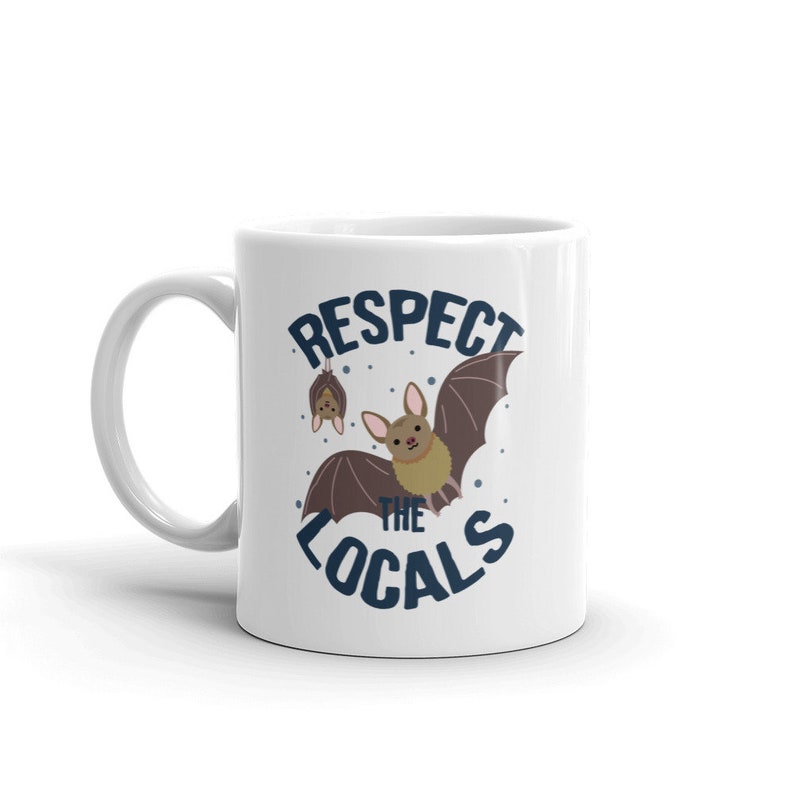 May include: White ceramic mug with a blue and white design featuring bats and the text "Respect the Locals".
