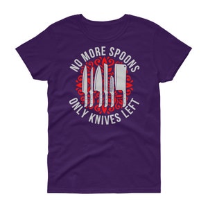 Puede incluir: Camiseta morada para mujer con un dise&ntilde;o gr&aacute;fico blanco de un c&iacute;rculo con cuchillos y el texto "No More Spoons Only Knives Left".