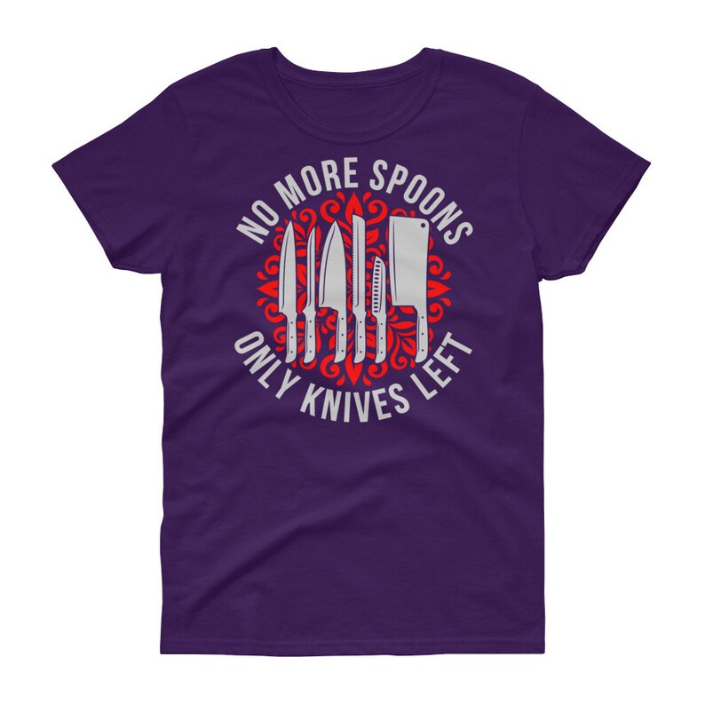 Puede incluir: Camiseta morada para mujer con un dise&ntilde;o gr&aacute;fico blanco de un c&iacute;rculo con cuchillos y el texto "No More Spoons Only Knives Left".
