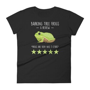 May include: Black women's t-shirt with a white graphic of a green tree frog. The text "Barking Tree Frogs - A Review -" is above the frog and the text "Frogs are very nice 5 stars" is below the frog. There are five white stars below the text.
