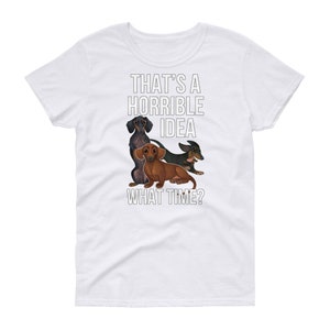 May include: White t-shirt with a graphic of three dachshund dogs and the text "That's a horrible idea. What time?"
