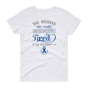 May include: White t-shirt with a blue ribbon and the text "SHE BELIEVED she could BUT SHE WAS REALLY Tired SO SHE DIDN'T" with arrows pointing to the left and right of the text.