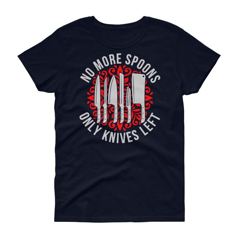 Puede incluir: Camiseta azul marino para mujer con un dise&ntilde;o gr&aacute;fico rojo y blanco. El gr&aacute;fico presenta un c&iacute;rculo con un patr&oacute;n floral rojo y el texto "No More Spoons Only Knives Left" en blanco. El c&iacute;rculo contiene un conjunto de cuchillos plateados.