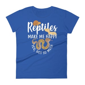 May include: A royal blue women's t-shirt with white text that reads "Reptiles make me happy, you not so much". The text is surrounded by cartoon images of a turtle, a bearded dragon, and a snake.