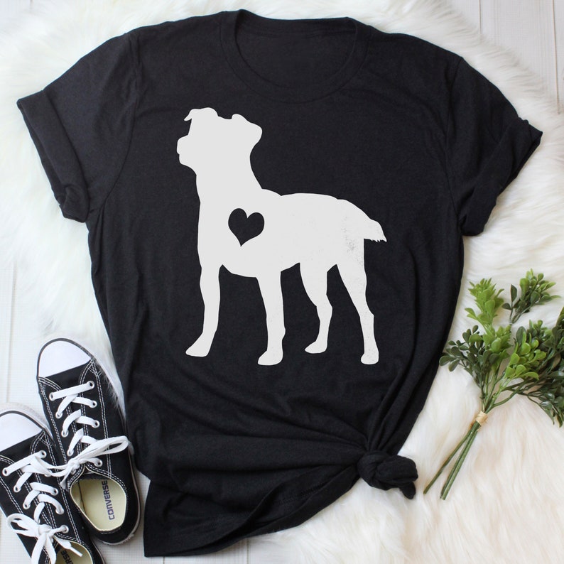 May include: Black t-shirt featuring a white silhouette of a dog with a heart in its chest.