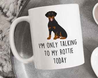 May include: White ceramic mug with a black and brown Rottweiler illustration and the text "I'M ONLY TALKING TO MY ROTTIE TODAY". The mug has a curved handle and is sitting on a gray tray.