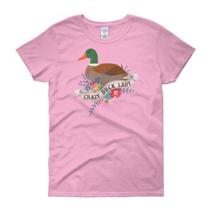 Puede incluir: Camiseta rosa para mujer con un pato de dibujos animados y flores. El texto "Crazy Duck Lady" est&aacute; impreso en la camiseta.