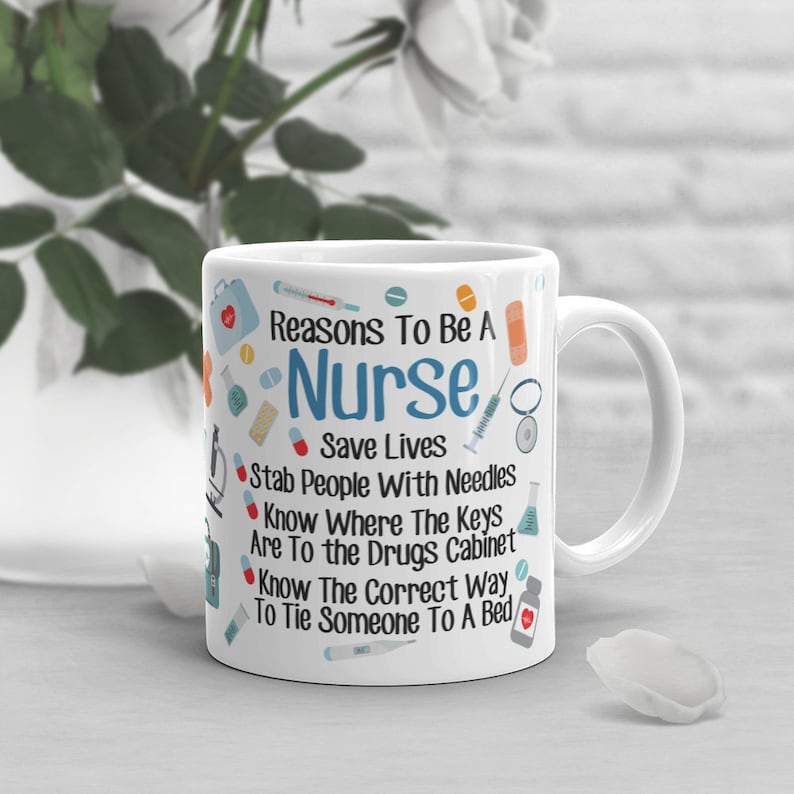 May include: White ceramic mug with a blue and red design. The mug features the text "Reasons To Be A Nurse" and a list of reasons, including "Save Lives", "Stab People With Needles", and "Know The Correct Way To Tie Someone To A Bed".