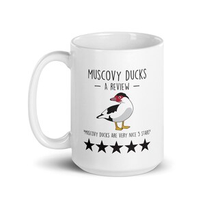 May include: White ceramic mug with a black and white illustration of a Muscovy duck. The text "Muscovy Ducks - A Review -" is printed on the mug, along with the text "Muscovy Ducks are very nice 5 stars" and five black stars.