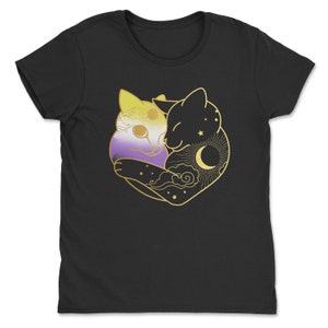 Op de afbeelding: Zwart t-shirt met een gouden afbeelding van twee omhelzende katten. E&eacute;n kat is geel, paars en wit gekleurd, de andere is een silhouet met een maan, sterren en zon. De katten omarmen elkaar.