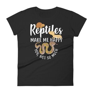 May include: Black women's t-shirt with white text that reads "Reptiles make me happy, you not so much". The text is surrounded by cartoon images of a turtle, a lizard, and a snake.